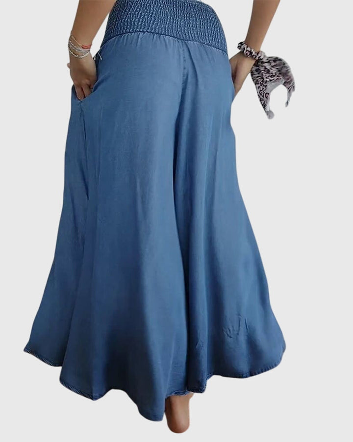 A woman in wide-leg trousers with a high elastic waist, styled for a relaxed boho look.