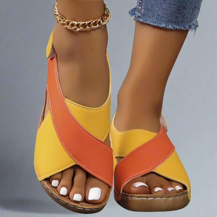 A woman walking outdoors in modern colourblock orthopaedic sandals with adjustable straps.