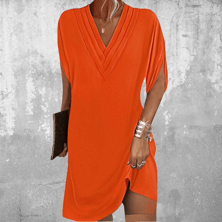 Woman wearing the Regina™ elegant V-neck dress with a relaxed straight silhouette at an evening occasion.