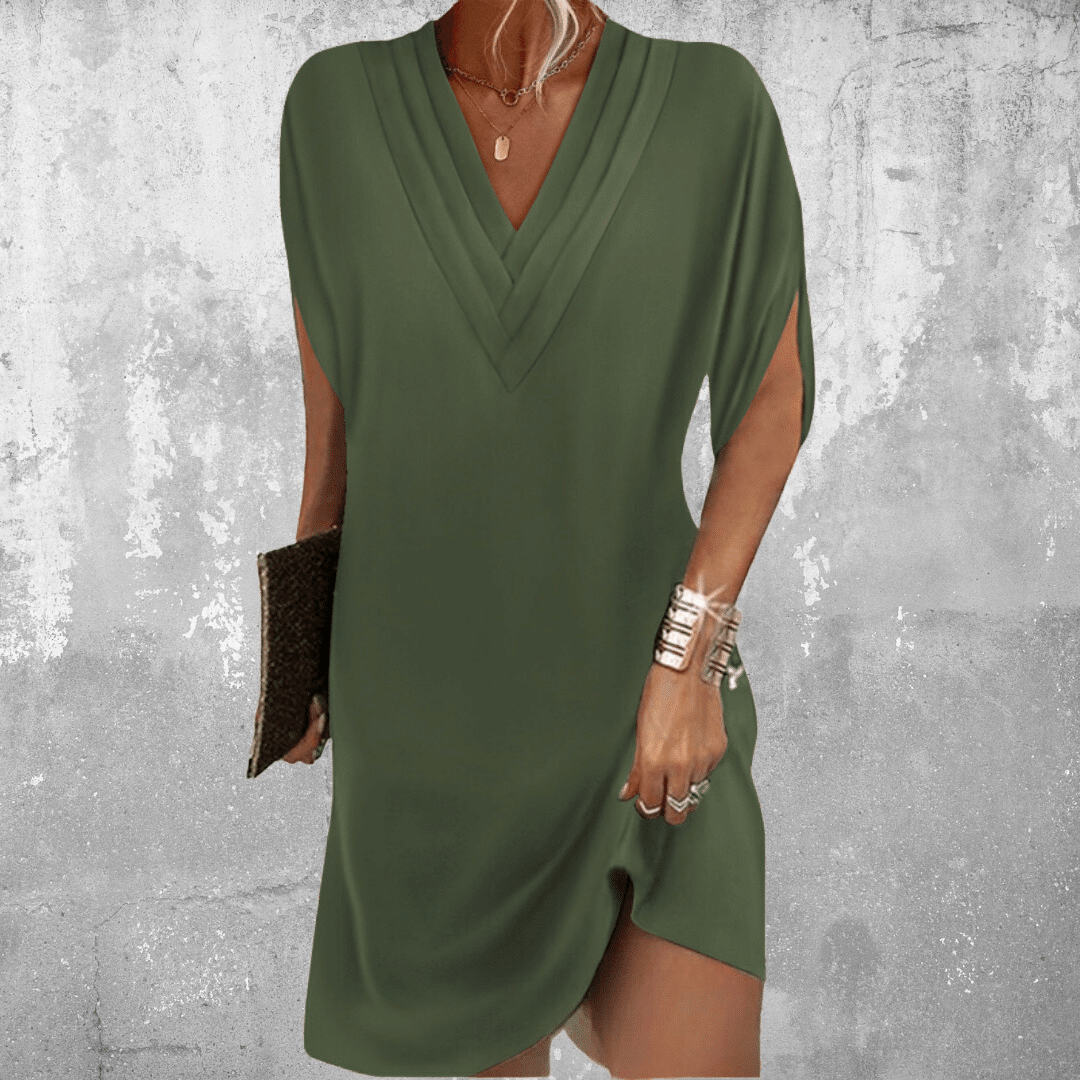 Woman wearing the Regina™ elegant V-neck dress with a relaxed straight silhouette at an evening occasion.