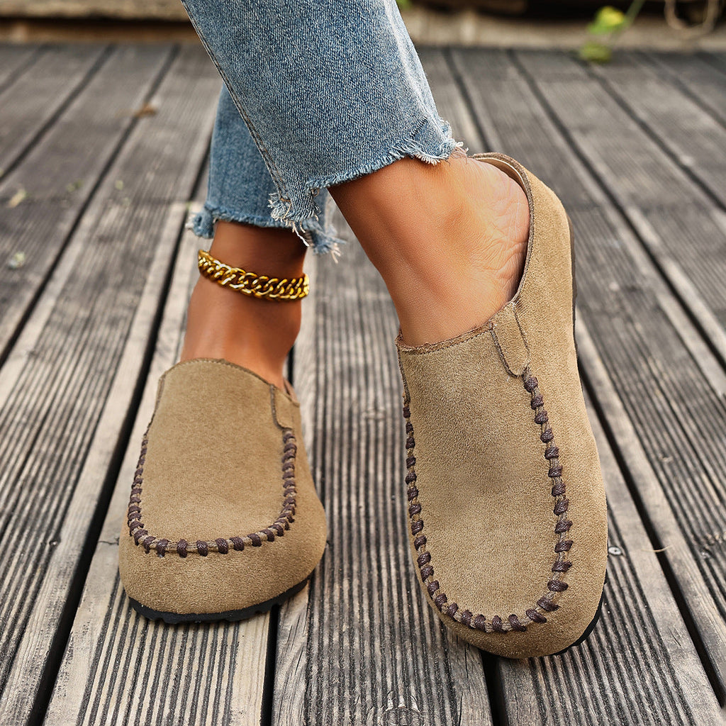 A pair of minimal slip-on loafers in warm brown with a soft footbed and open back