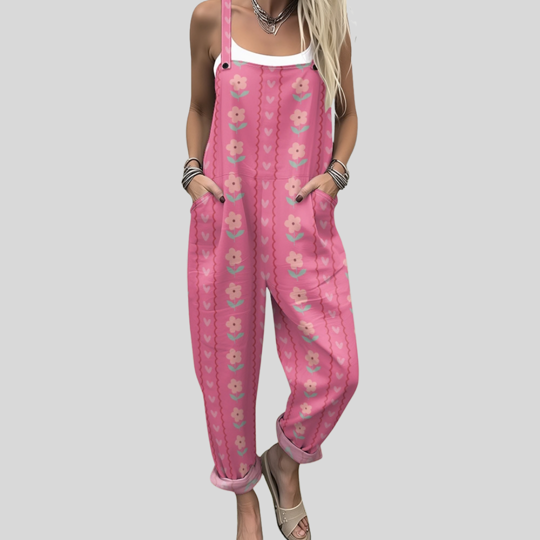 Wide-leg warm-pink dungarees with retro daisy blooms in vertical columns and soft wavy stripe dividers, adjustable straps, from Mary Cork Ireland.