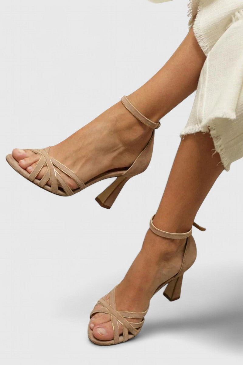 A woman slipping on elegant brown heels, ready for a day that runs into evening.
