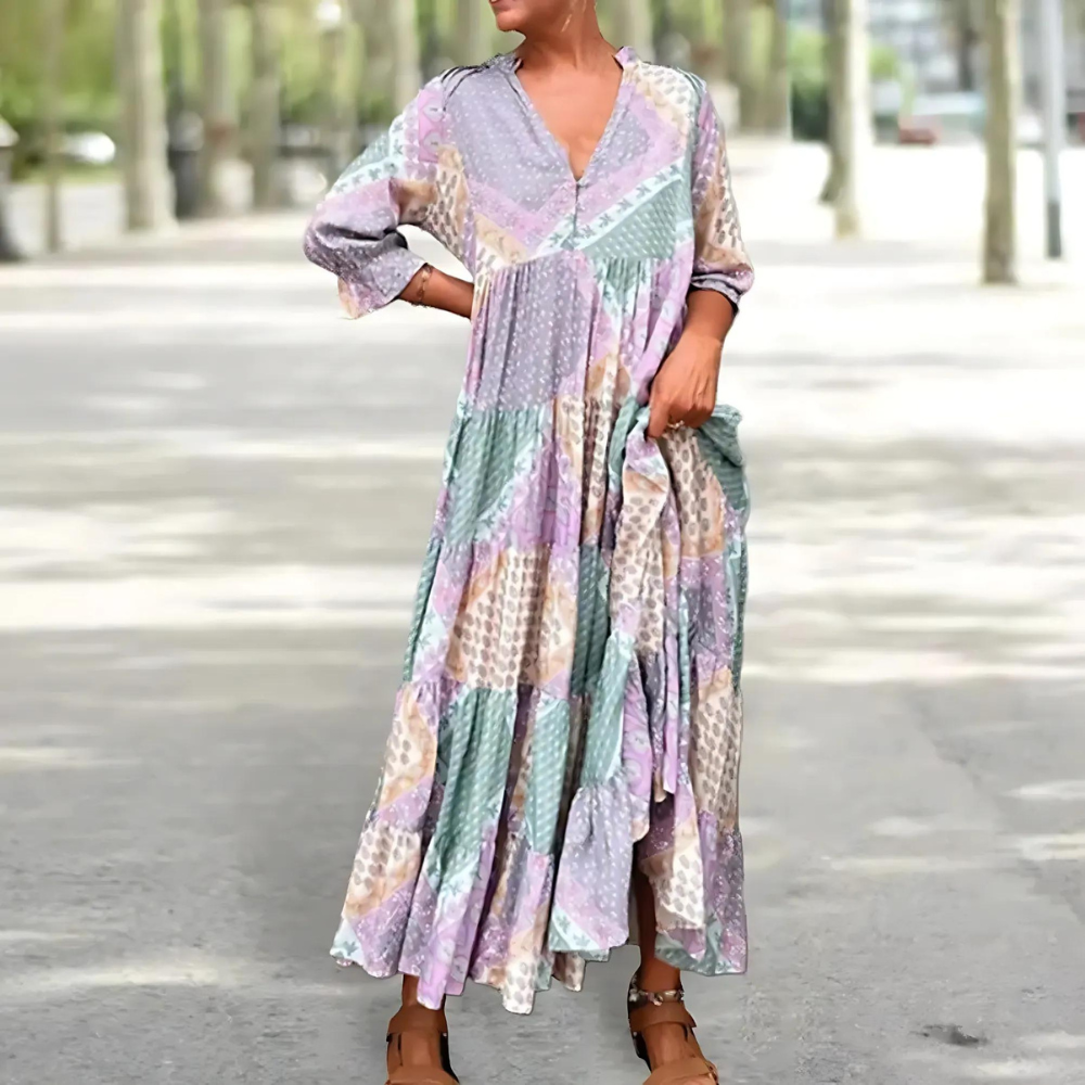 Woman in the Beatrice patchwork print maxi dress with a V-neckline, standing relaxed in soft summer light.