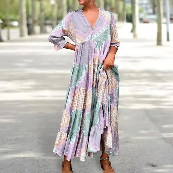 Woman in the Beatrice patchwork print maxi dress with a V-neckline, standing relaxed in soft summer light.