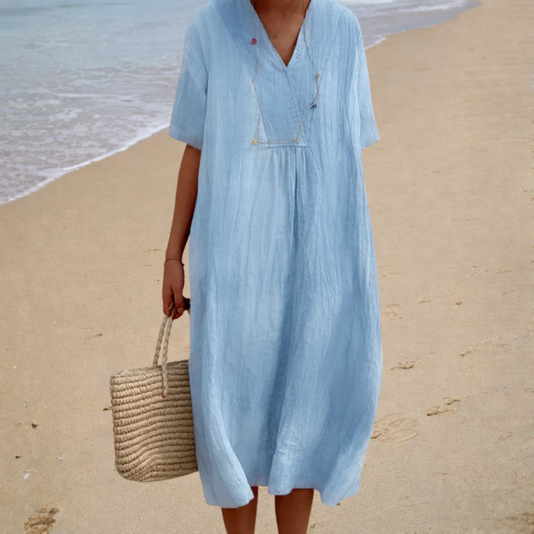 A woman wearing a light patterned summer dress with a relaxed, flowing shape.