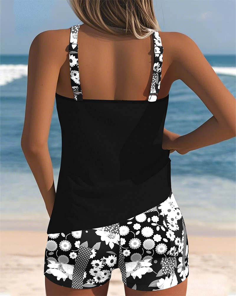Floral tankini with shorts bottom in purple and soft tones, displayed on a light background