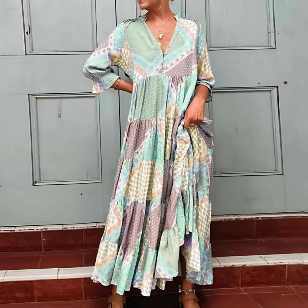 Woman in the Beatrice patchwork print maxi dress with a V-neckline, standing relaxed in soft summer light.