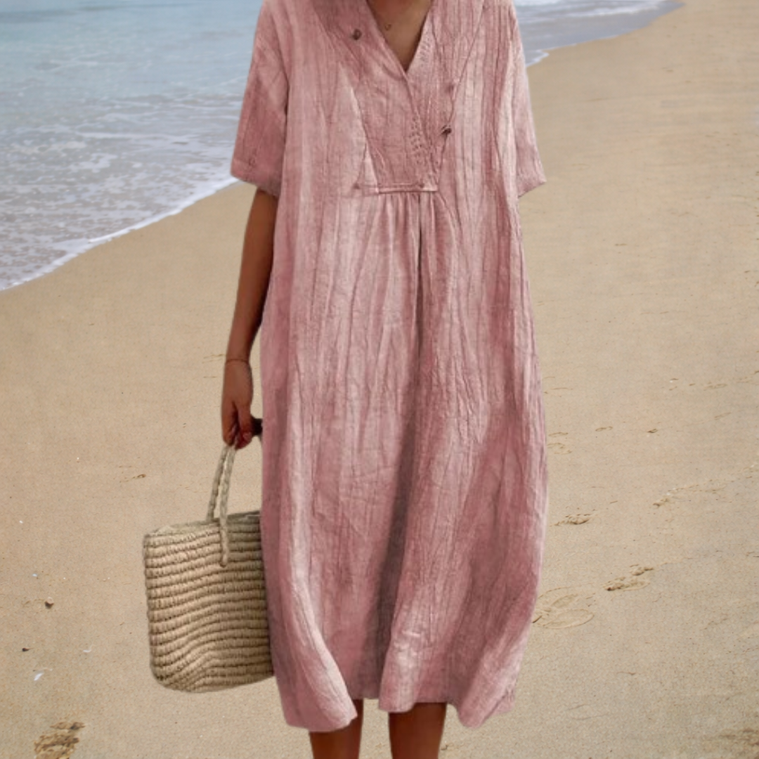 A woman wearing a light patterned summer dress with a relaxed, flowing shape.