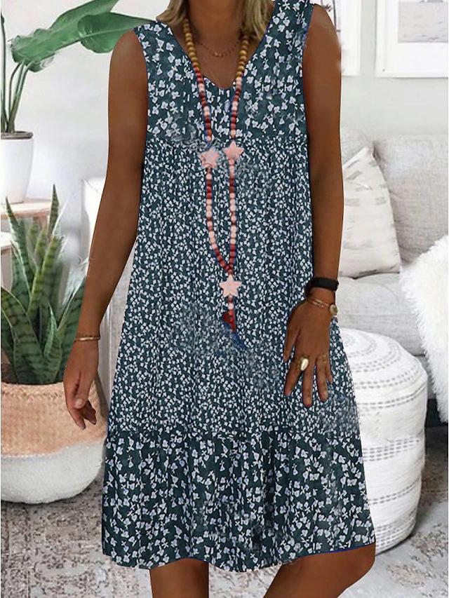 A woman wearing the Geraldine sleeveless V-neck floral dress on a sunny day outdoors.
