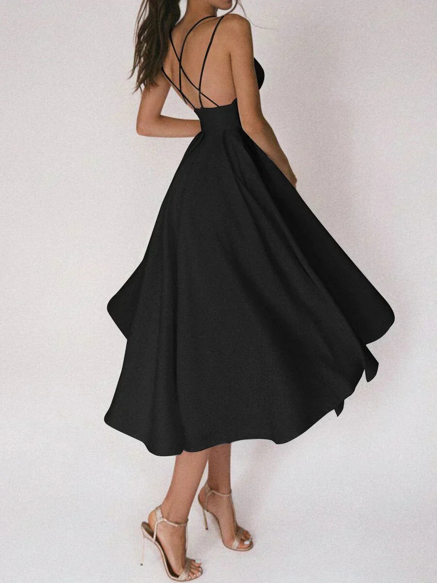 Woman at a summer celebration wearing the Katie minimalist maxi dress with fine double straps and a floating skirt.