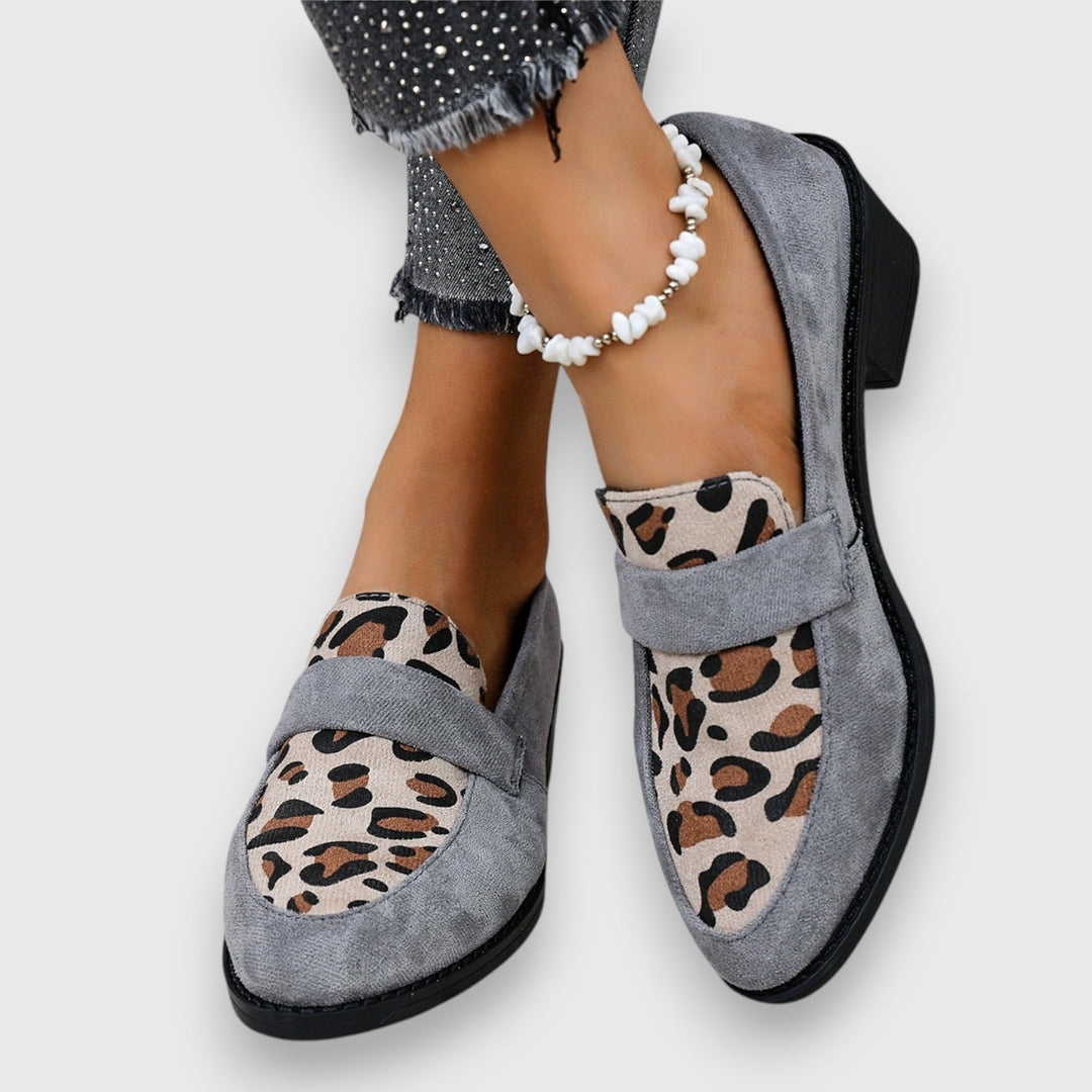 A woman wearing soft grey house slippers, relaxing comfortably at home.