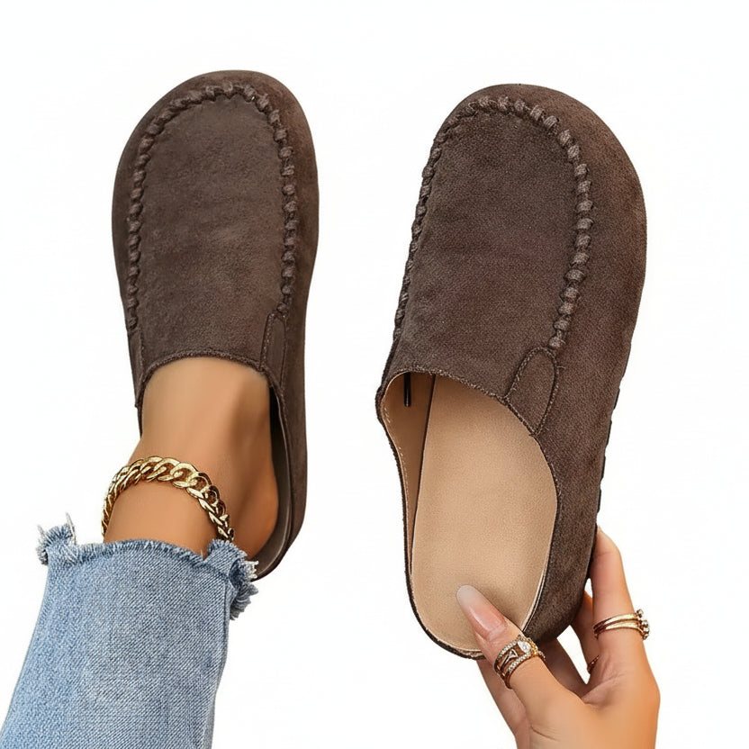 A pair of minimal slip-on loafers in warm brown with a soft footbed and open back