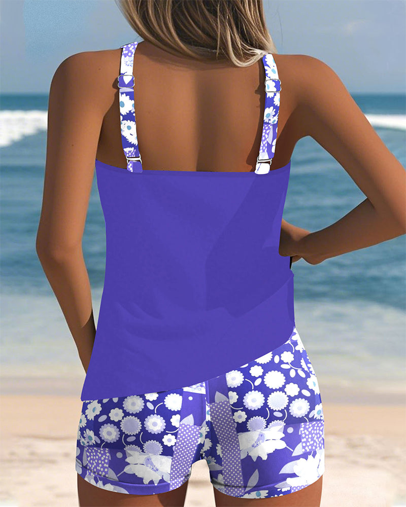 Floral tankini with shorts bottom in purple and soft tones, displayed on a light background