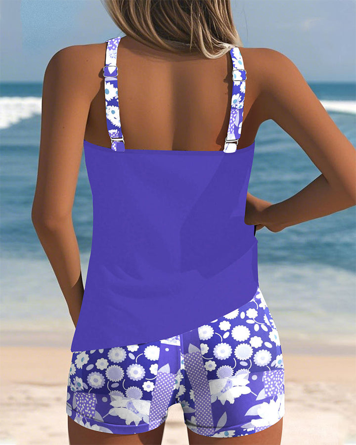 Floral tankini with shorts bottom in purple and soft tones, displayed on a light background