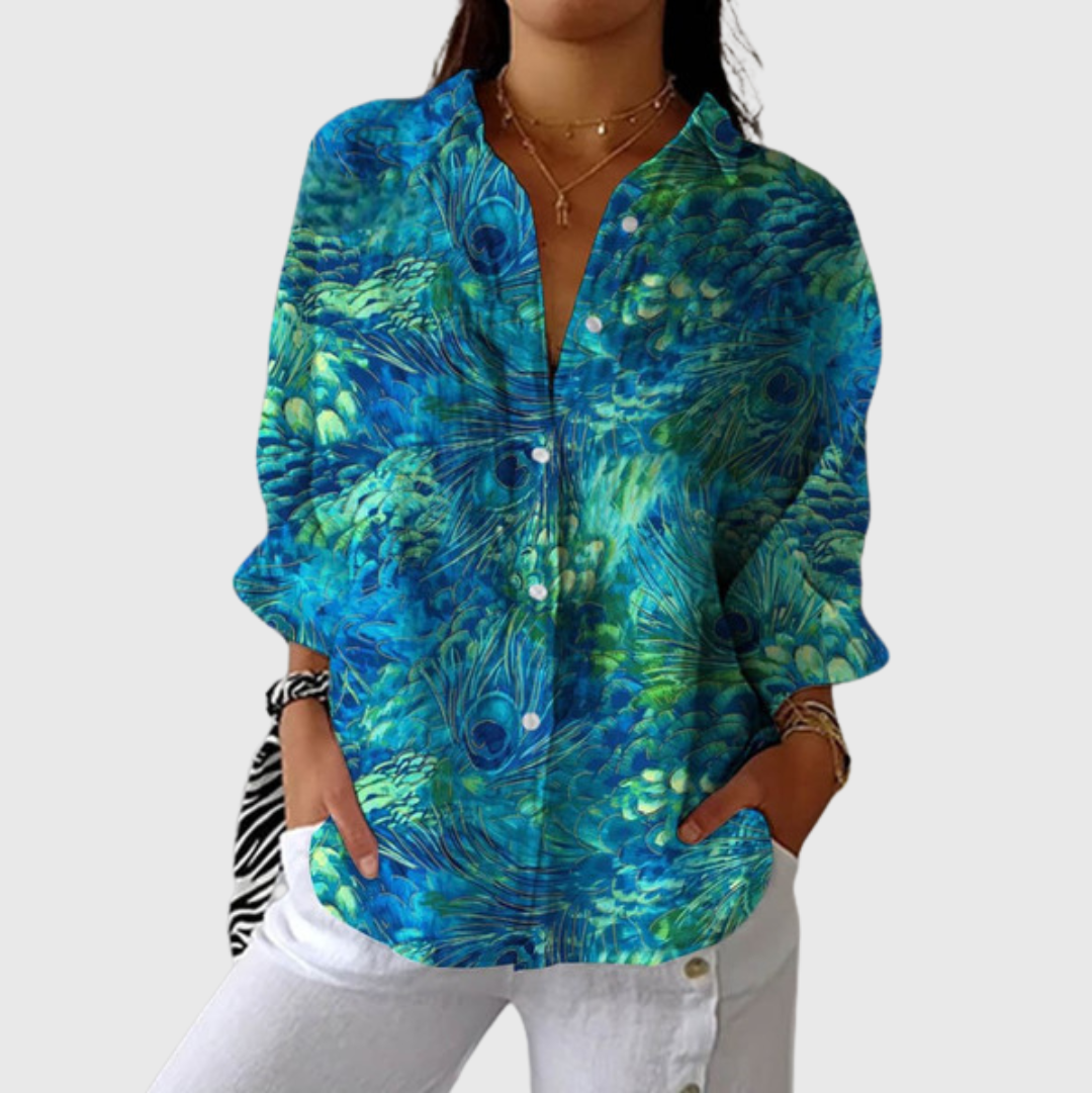 A woman in a colourful floral button-front blouse worn loosely over jeans