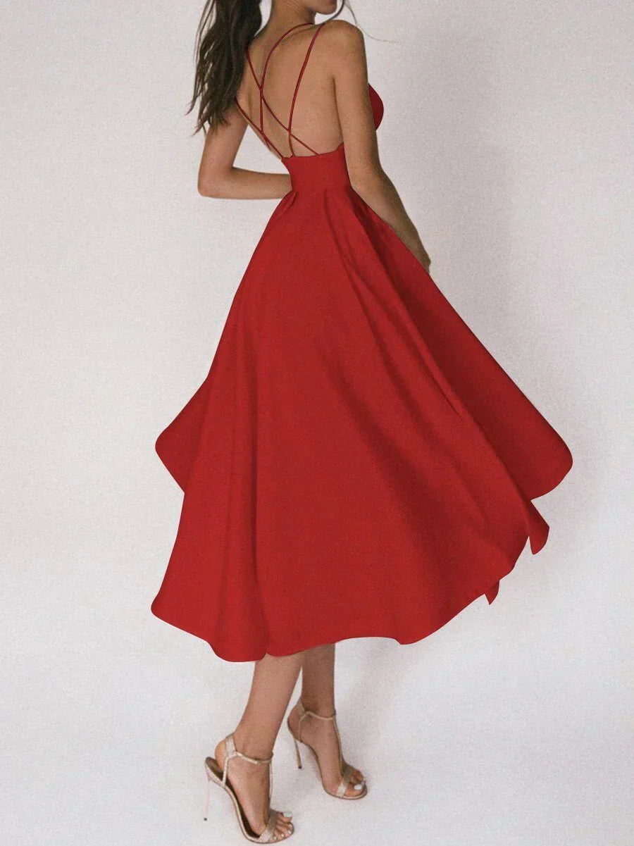 Woman at a summer celebration wearing the Katie minimalist maxi dress with fine double straps and a floating skirt.