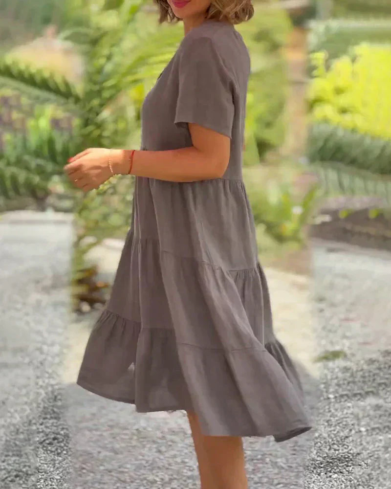 Woman wearing the Veronica™ V-neck summer dress with a soft layered skirt, strolling on a sunny afternoon.