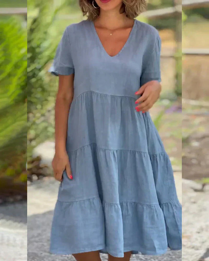 Woman wearing the Veronica™ V-neck summer dress with a soft layered skirt, strolling on a sunny afternoon.