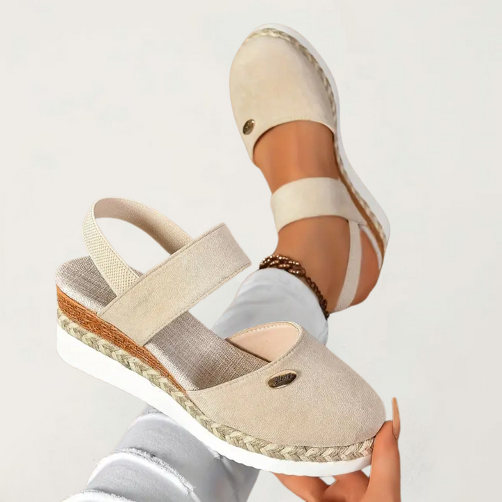 A woman walking comfortably in black cushioned support sandals with adjustable straps.