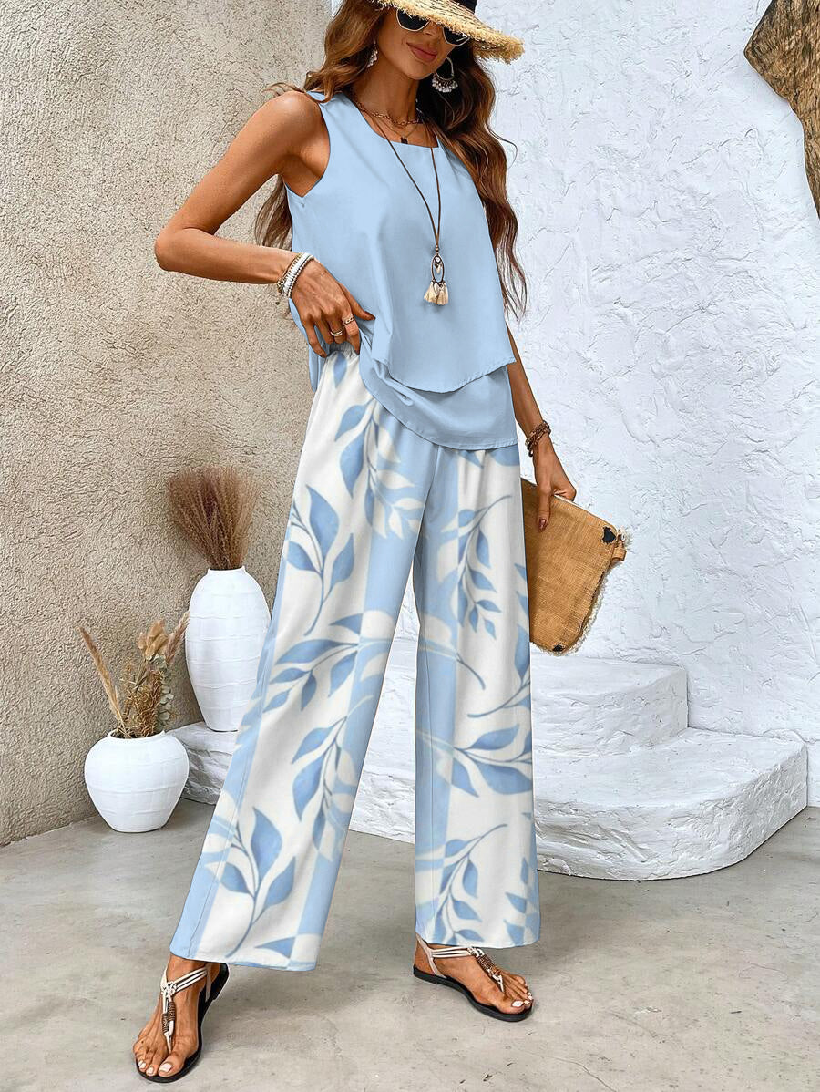 A woman wearing a layered sleeveless top with leaf-print wide-leg trousers, light and elegant.