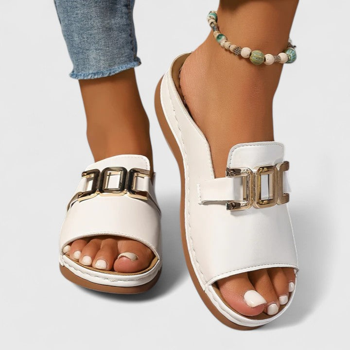 A woman walking easily in grey supportive sandals with a cushioned sole and adjustable strap.