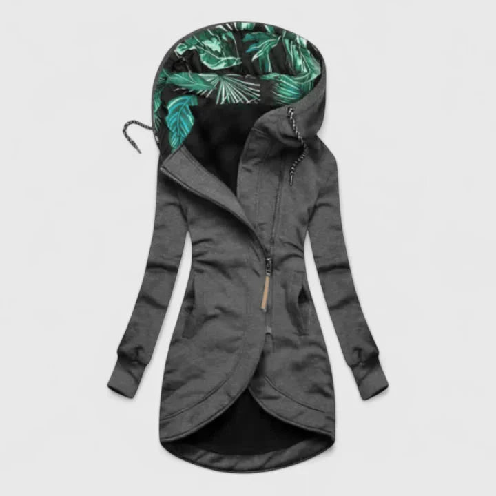 A woman wearing a weatherproof jacket, standing outdoors on a rainy day