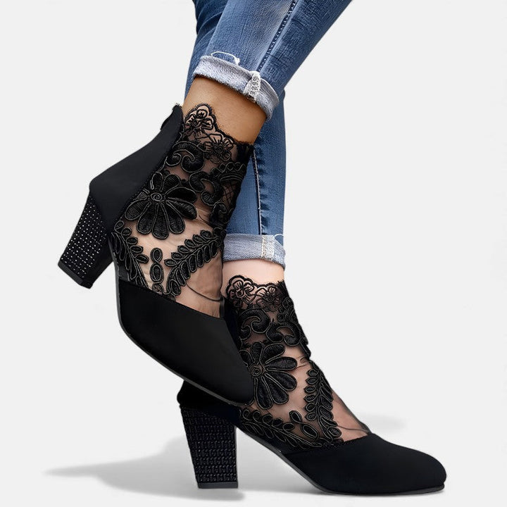 A woman wearing wide-toe orthopaedic heels, standing comfortably in an elegant everyday look.