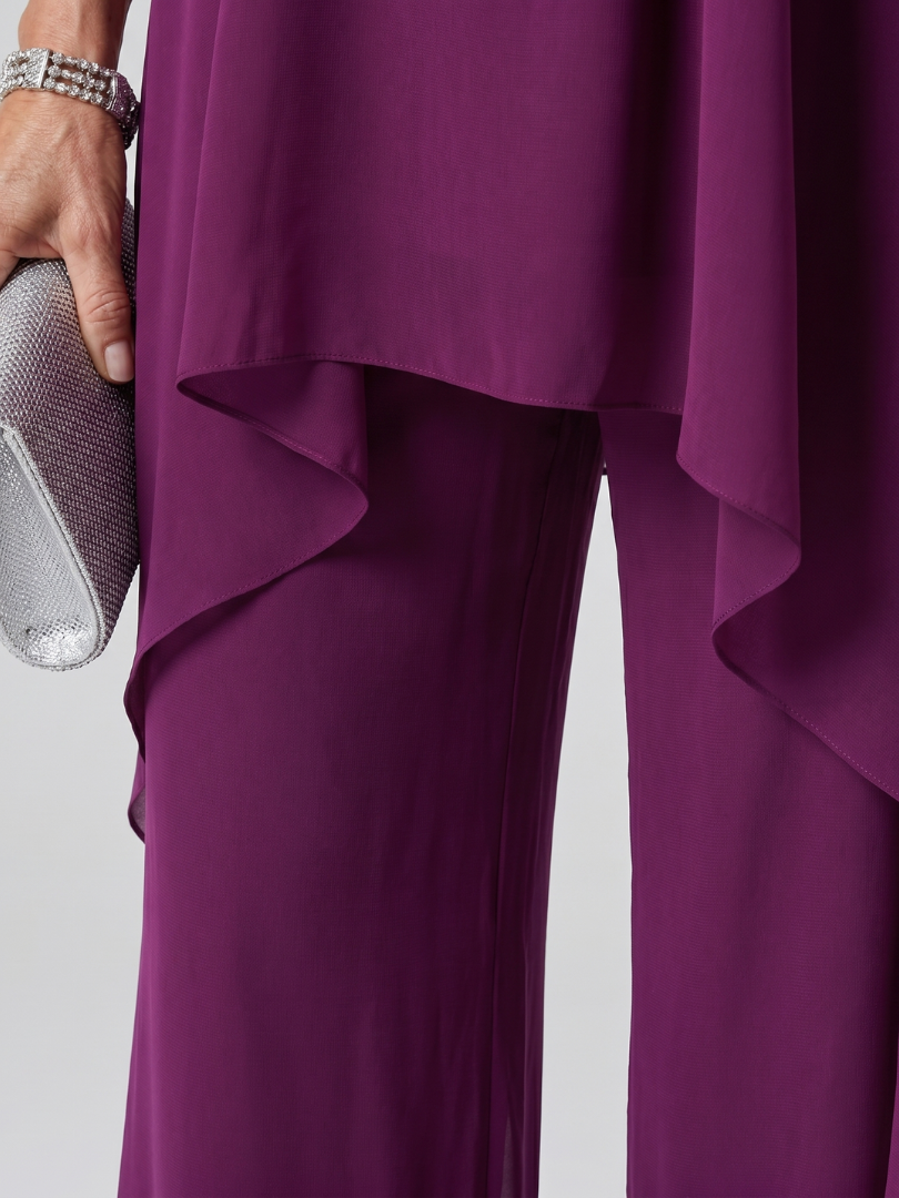 Purple halter neck tunic top with matching wide-leg trousers and a sheer asymmetric overlay