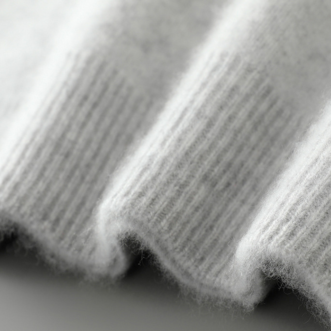 A woman wearing a soft luxe crew neck jumper with a matte finish, styled with smart trousers.