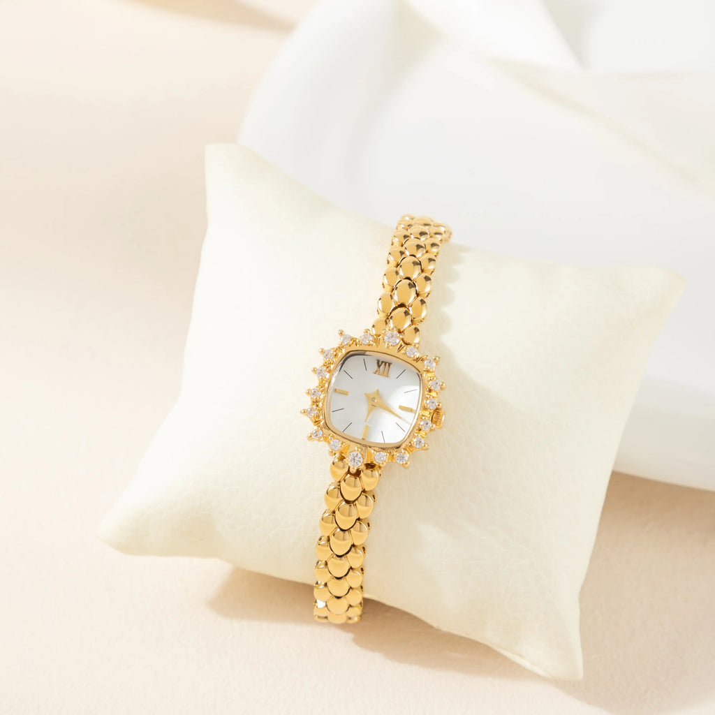Slim women's bracelet watch with a vibrant colour detail against a simple light dial