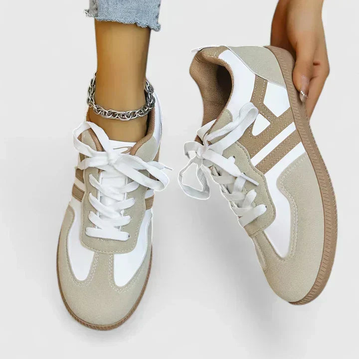 A woman wearing khaki and white orthopaedic trainers on a relaxed walk.