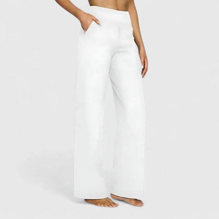 Woman wearing pull-on trousers with a soft blouse, relaxed and comfortable at home.
