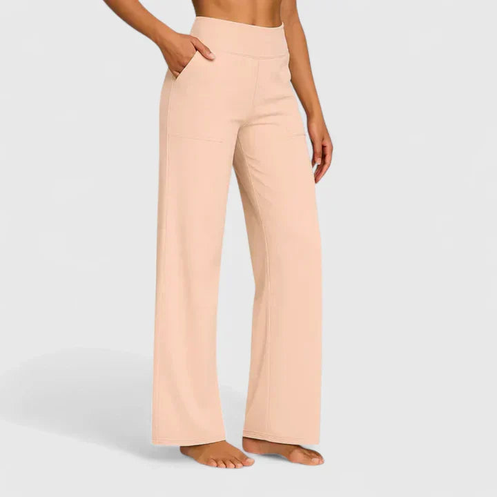 A woman in tailored trousers styled with a simple top for an elegant, comfortable everyday look.