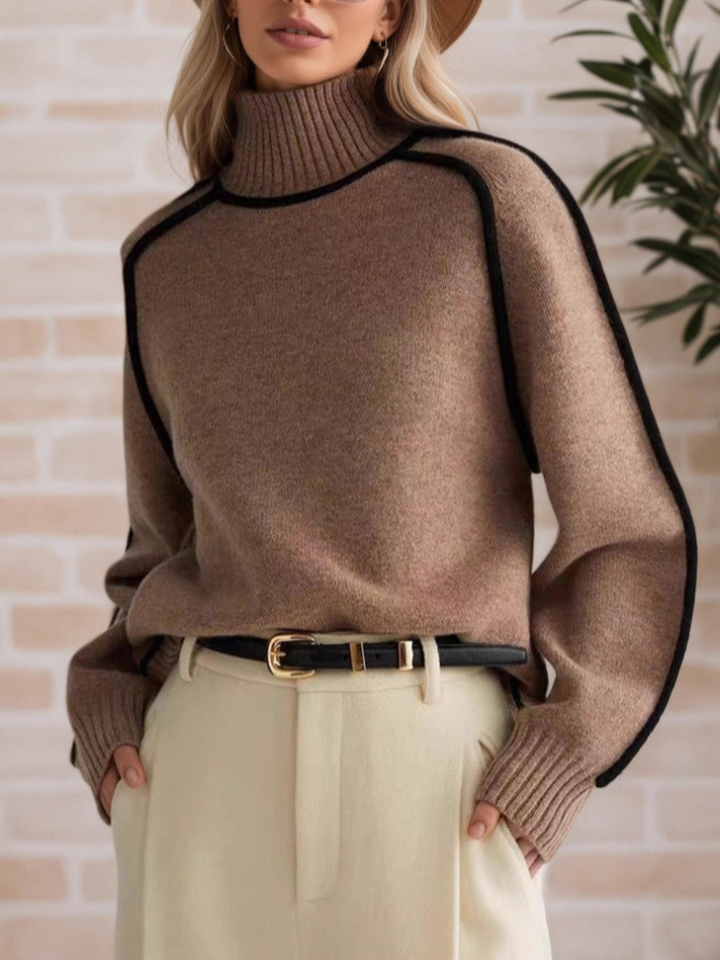 A woman wearing a funnel neck jumper with contrast piping, styled with trousers for a smart-casual look.