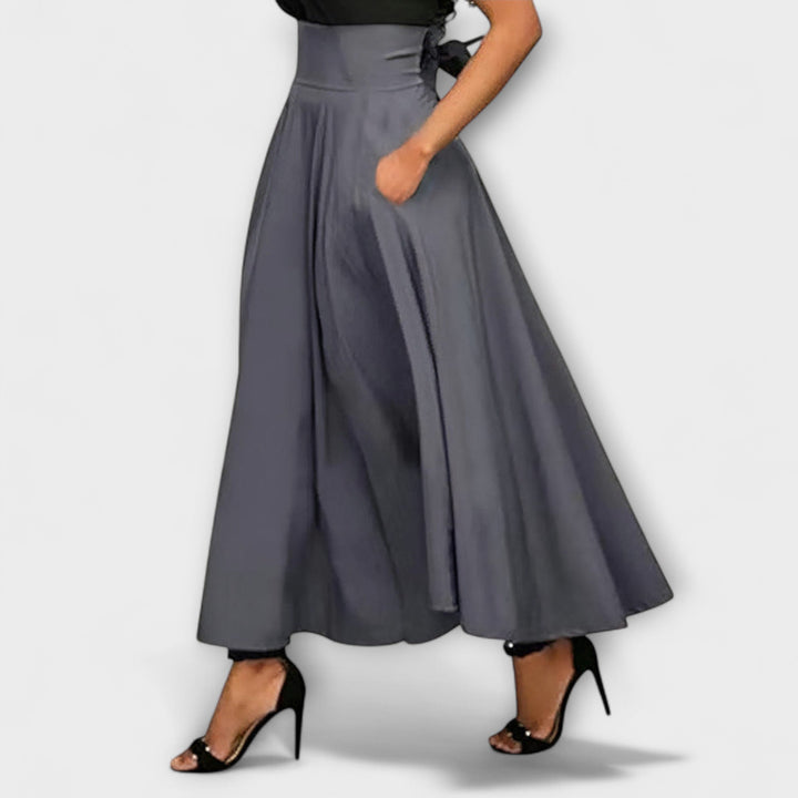 A woman in a flowing elegant maxi skirt styled with a simple top for a confident, striking look.