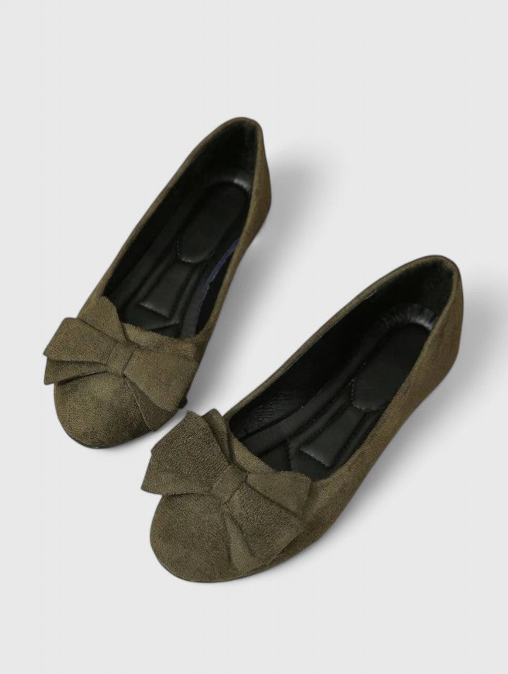 A woman walking easily in dark green classic comfort sandals with a broad, cushioned footbed.