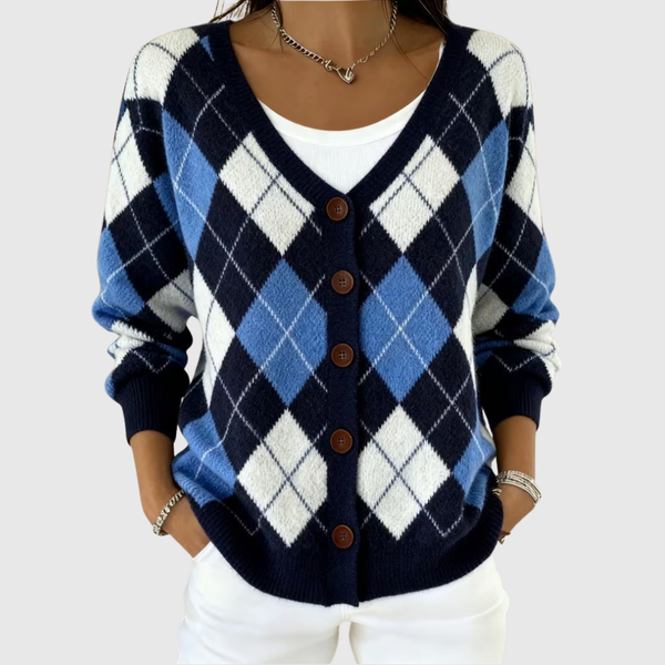 A woman wearing a navy and blue argyle button cardigan over a white top.
