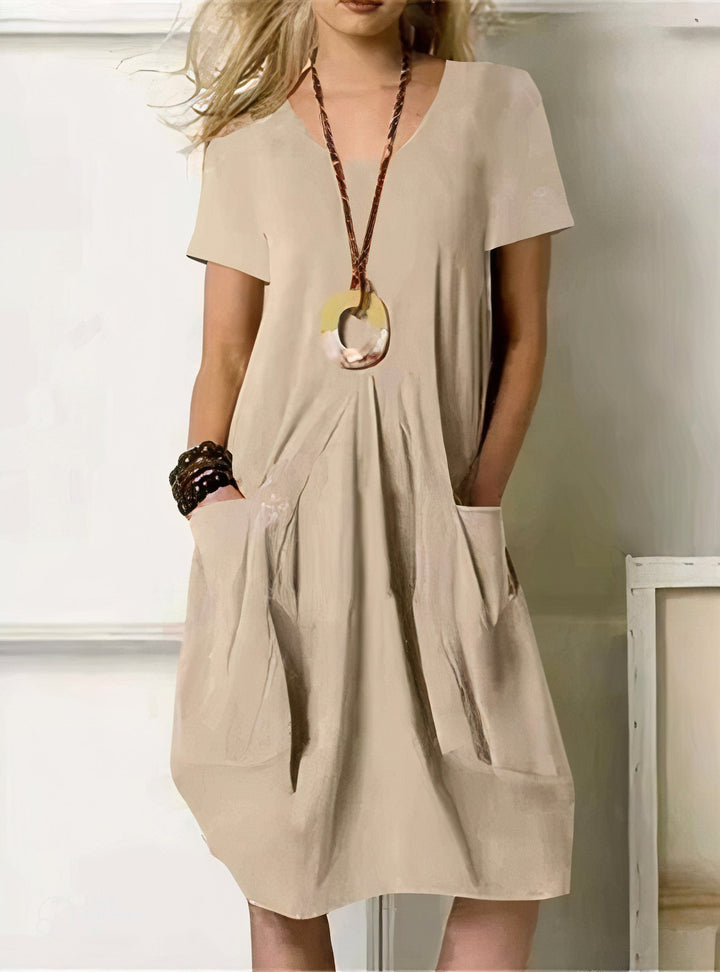 Woman wearing the Pauline™ A-line midi dress with pockets and a round neckline, out on an everyday errand.