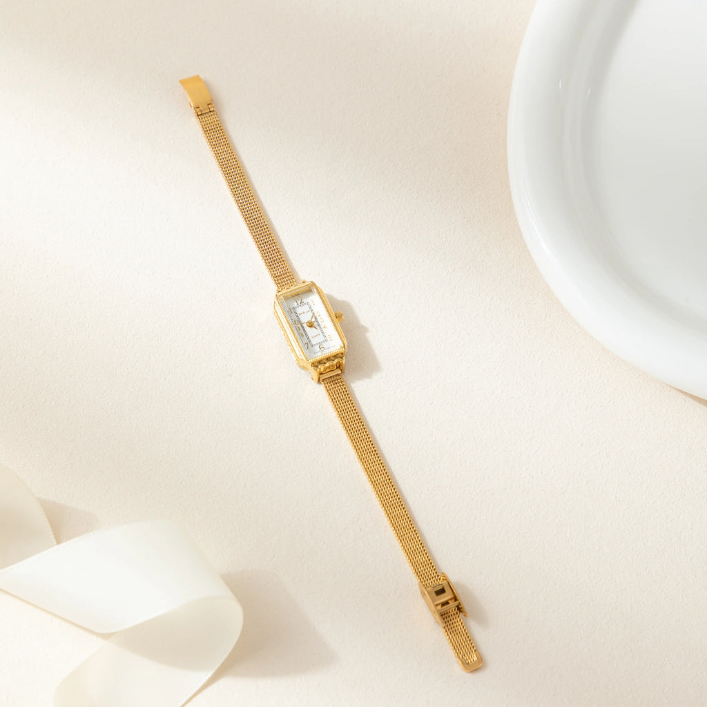 Women's classic watch with a textured strap and rounded dial in warm gold tone