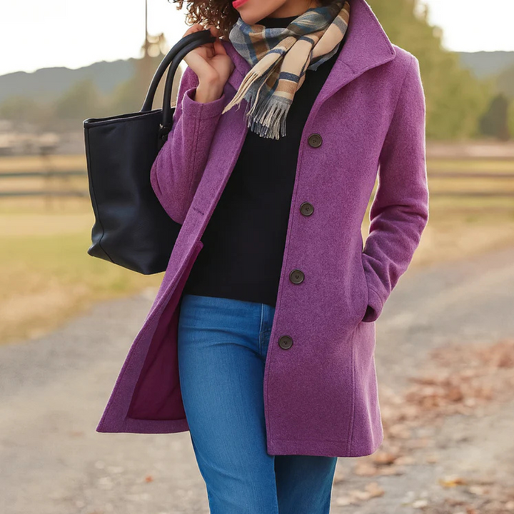 A woman wearing an elegant single-button coat over a jumper on a crisp autumn day.