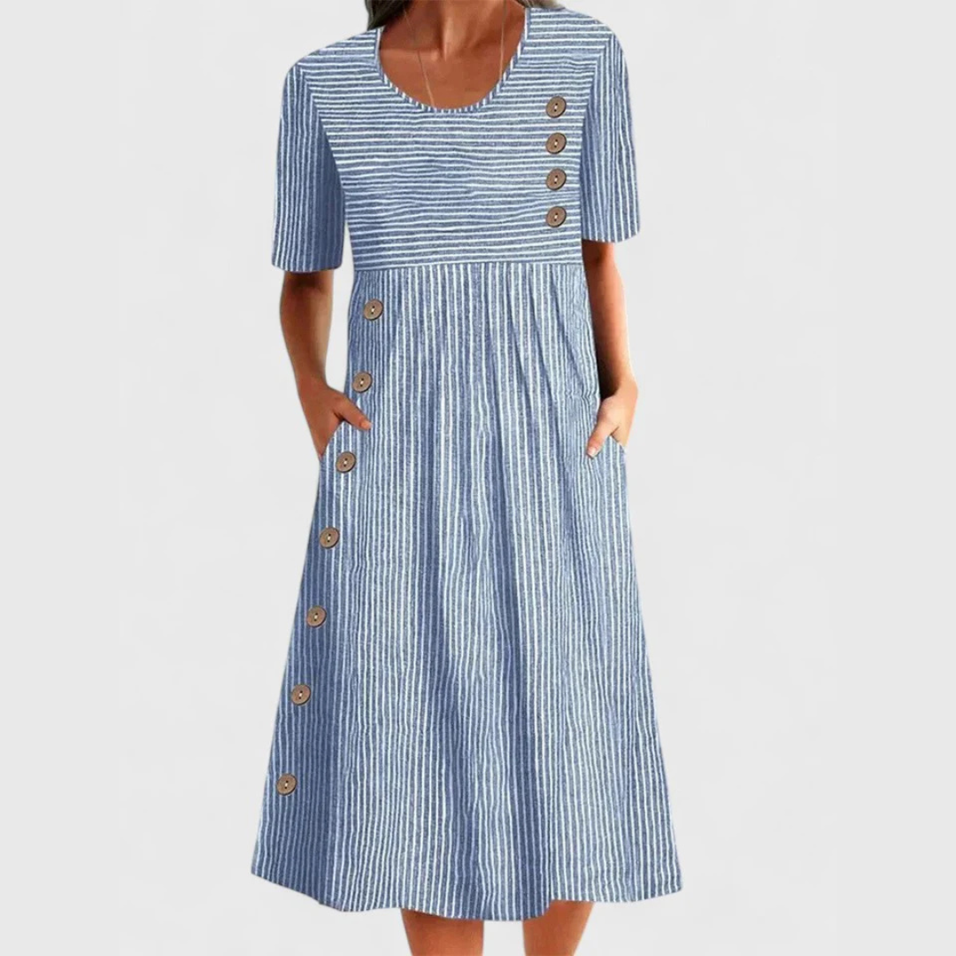 A woman wearing the Margaret striped midi dress with button details, standing outdoors on a bright day.