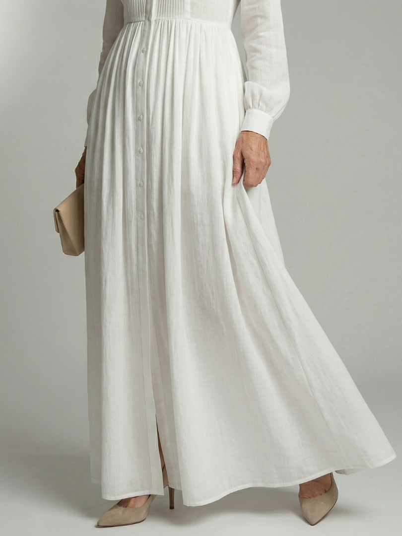 White long-sleeve button-front maxi dress with a gathered waist and full flowing skirt