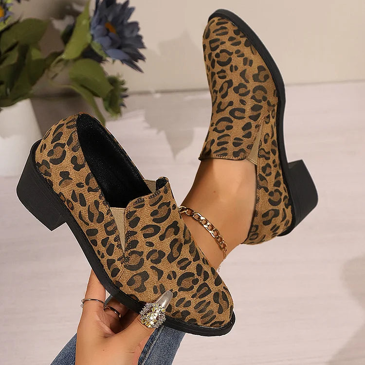 A woman wearing leopard-print loafers with jeans, stepping out with easy confidence.