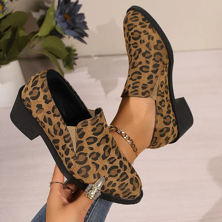 A woman wearing leopard-print loafers with jeans, stepping out with easy confidence.