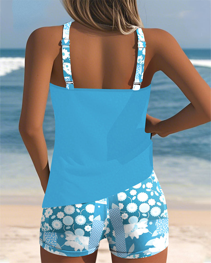 Floral tankini with shorts bottom in purple and soft tones, displayed on a light background