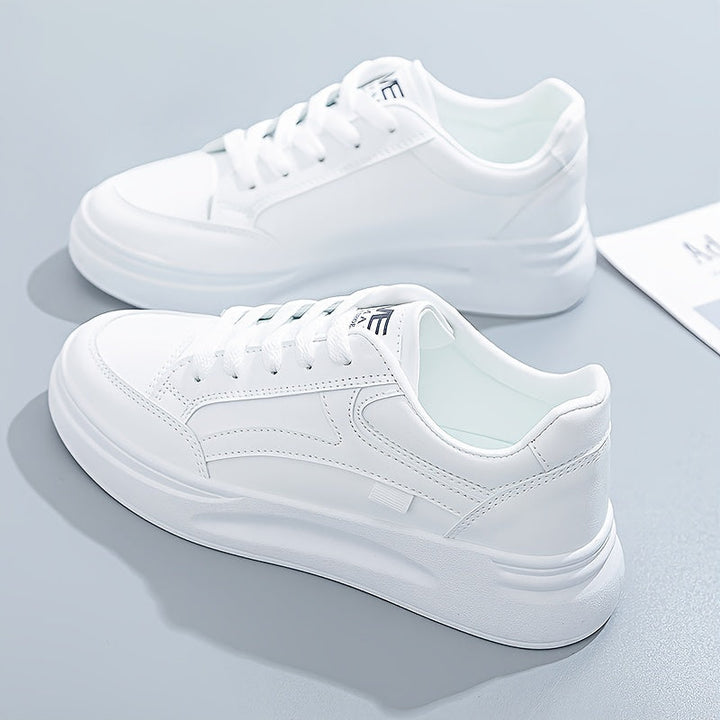 A woman in crisp white light comfort trainers paired with jeans.