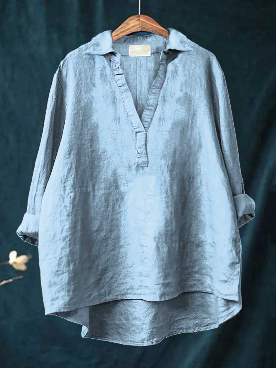 A woman wearing an elegant solid-colour summer blouse with an open V-neck, looking fresh and stylish on a warm day.