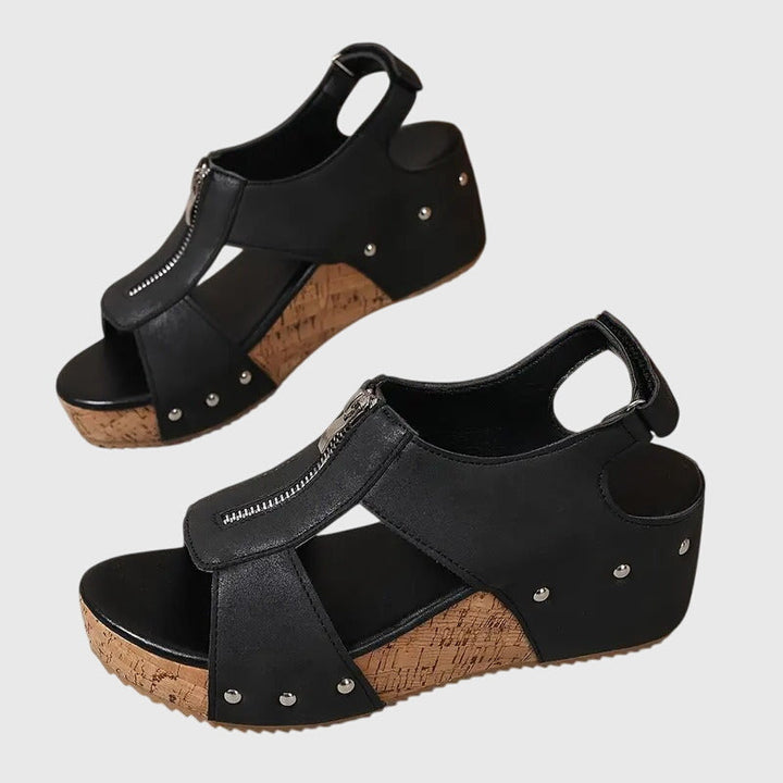 A woman standing at ease in wide-fit supportive comfort sandals with adjustable straps.