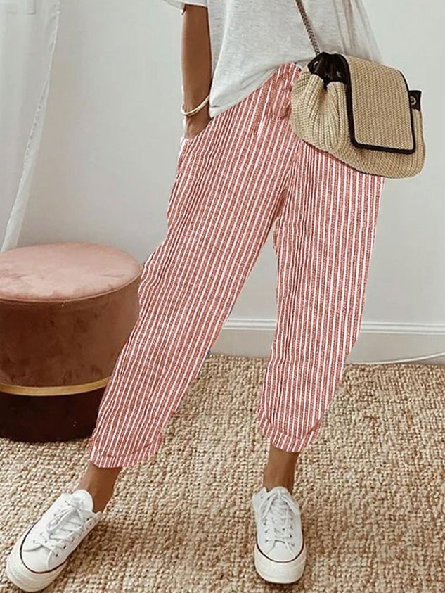 A woman wearing flowing elegant trousers with a soft elastic waist and deep pockets.